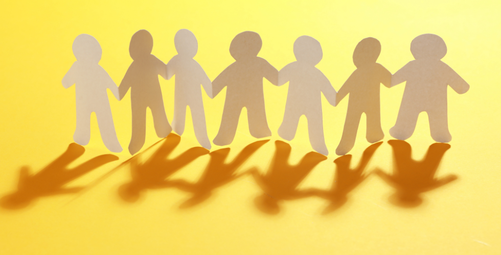 paper people chain on yellow background 